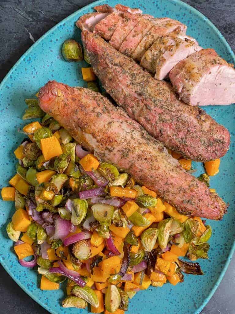 roasted pork tenderloin in the oven, served with brussels sprouts and fall veggies