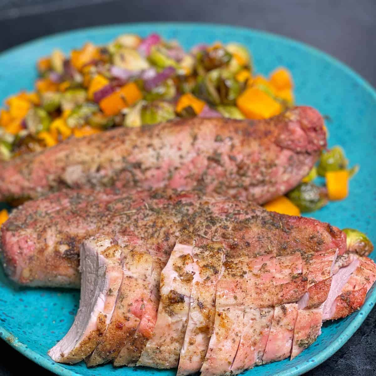 roasted pork tenderloin in the oven, served with burssels sprouts and fall veggies