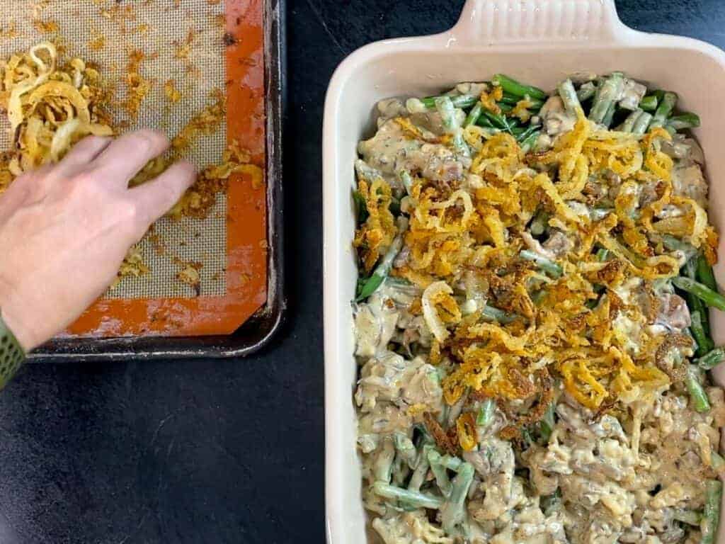 top the green bean casserole with the remaining crispy onions