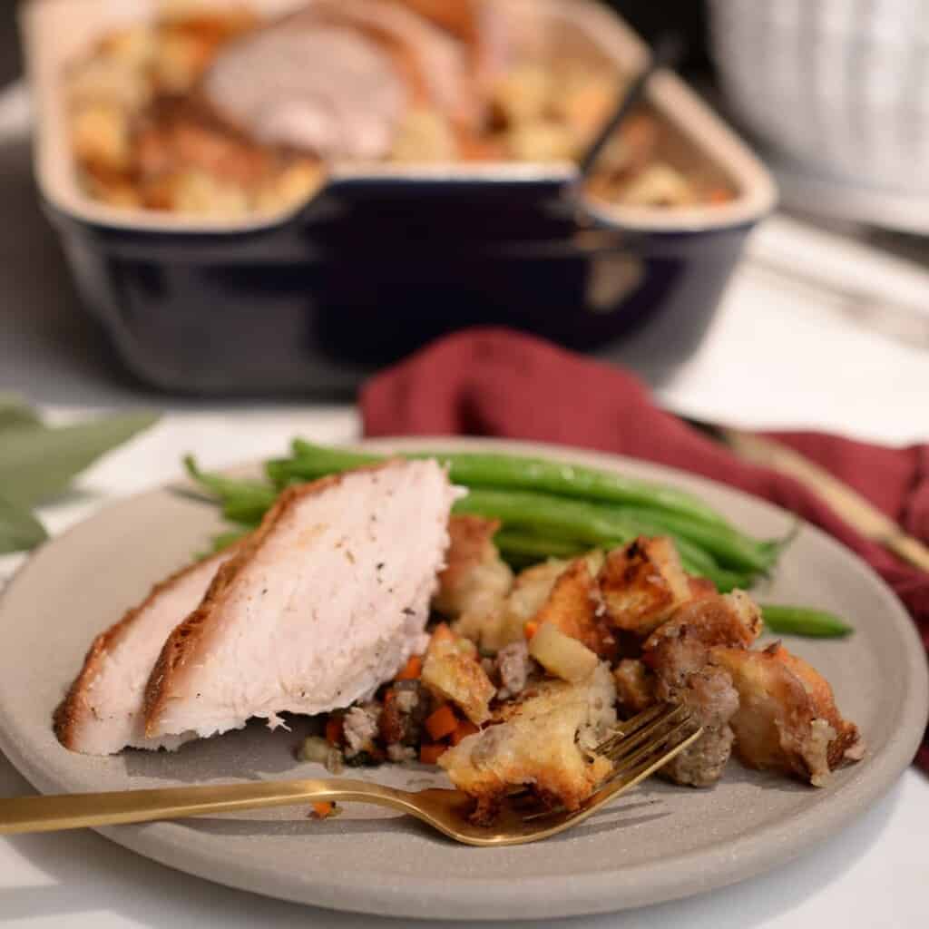 two slices of turkey with stuffing and green beans