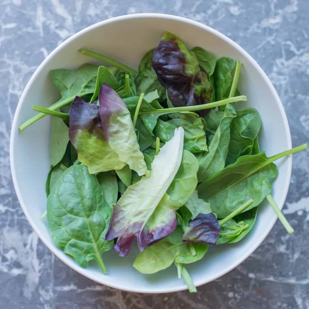 greens added to a meal prep bowl