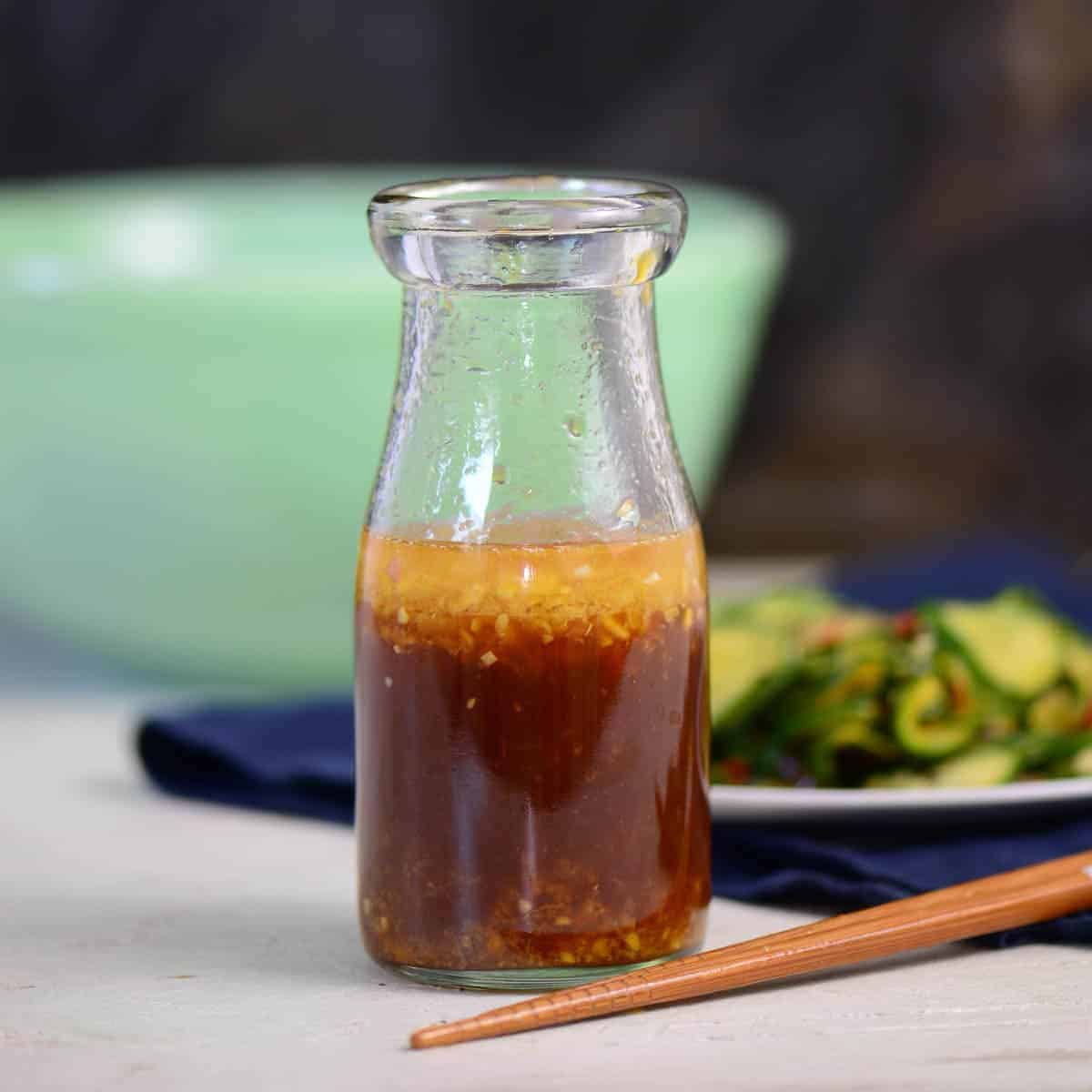 Asian Sesame Ginger Salad Dressing Recipe with chopsticks in a glass bottle