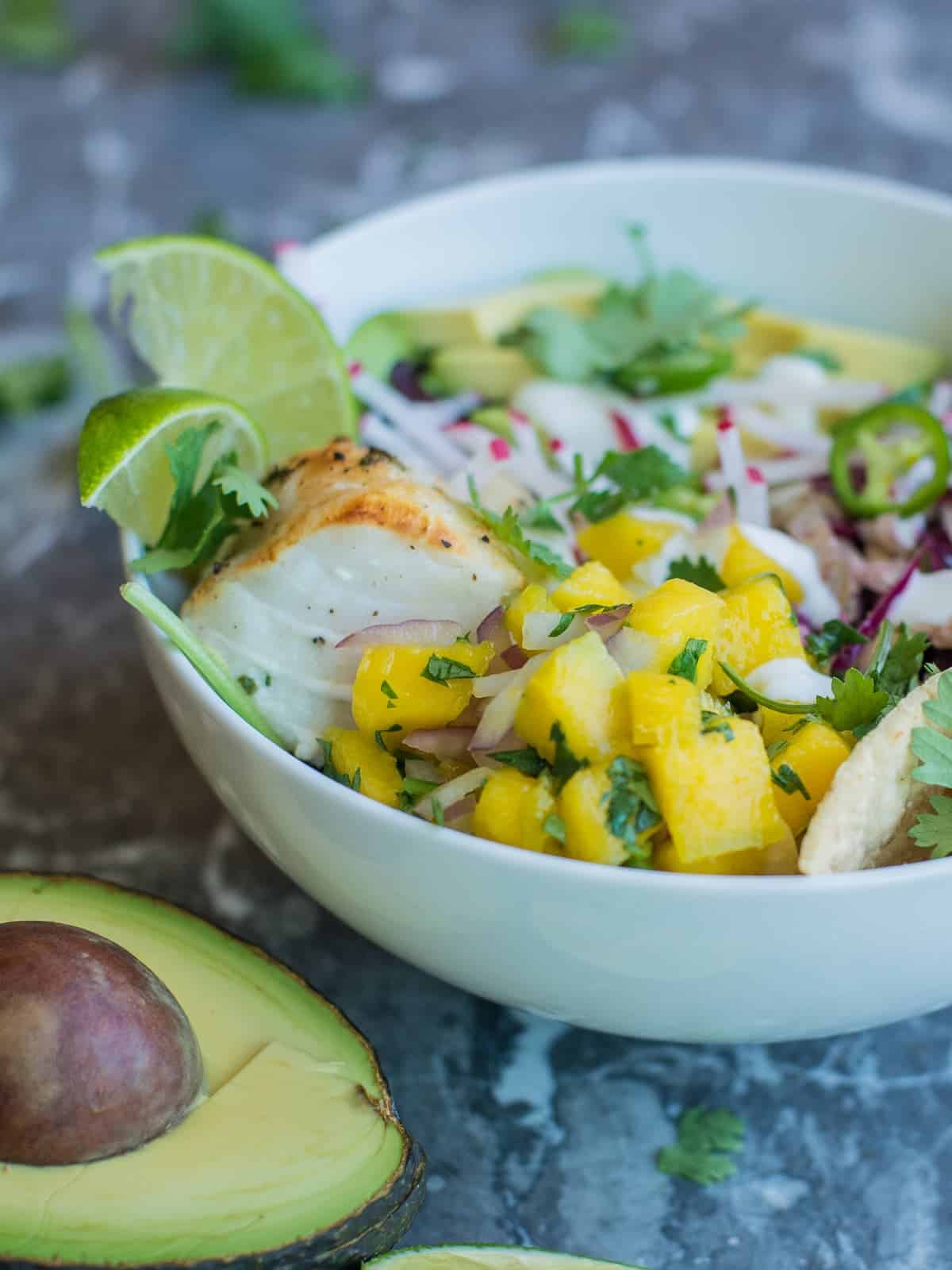 healthy fish taco bowl, fresh mango slasa on top