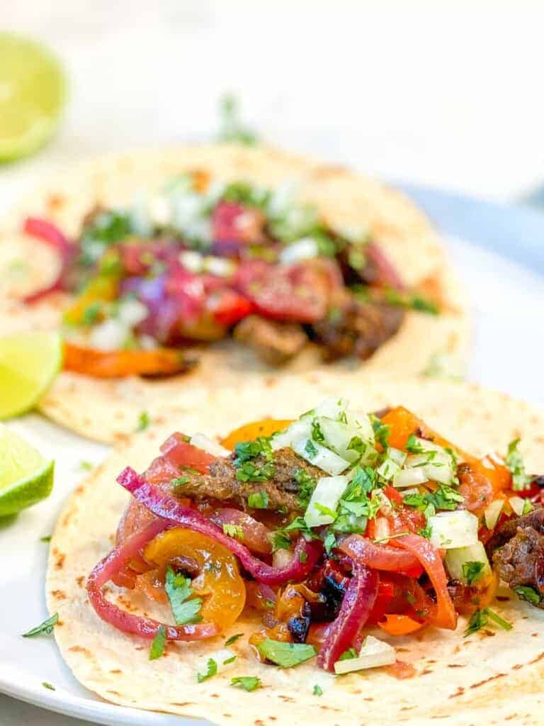 steak fajitas with tortillas and limes