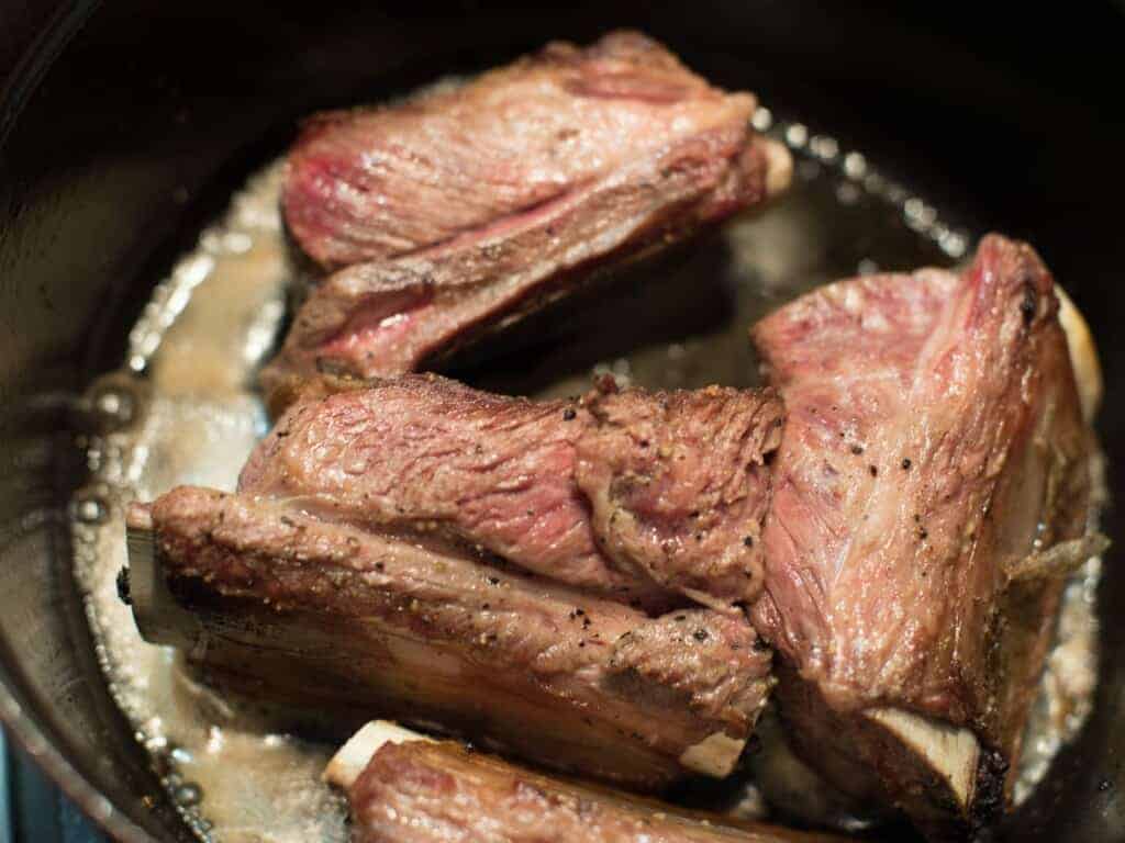 browning beef short ribs in a heavy dutch oven pan