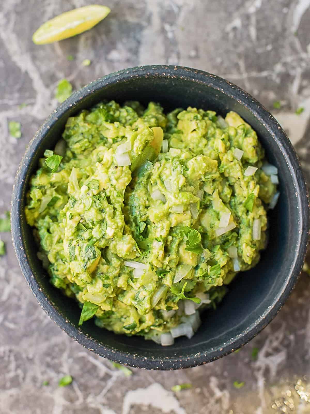 fresh guacamole recipe in a balck stone bowl