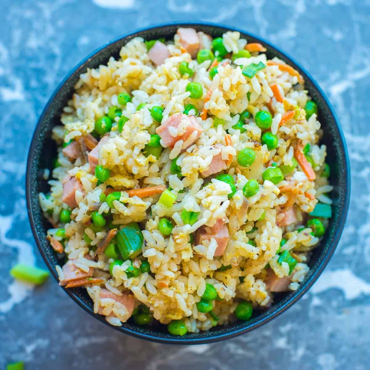 fried spam recipe recipe made with peas and carrots in a black bowl