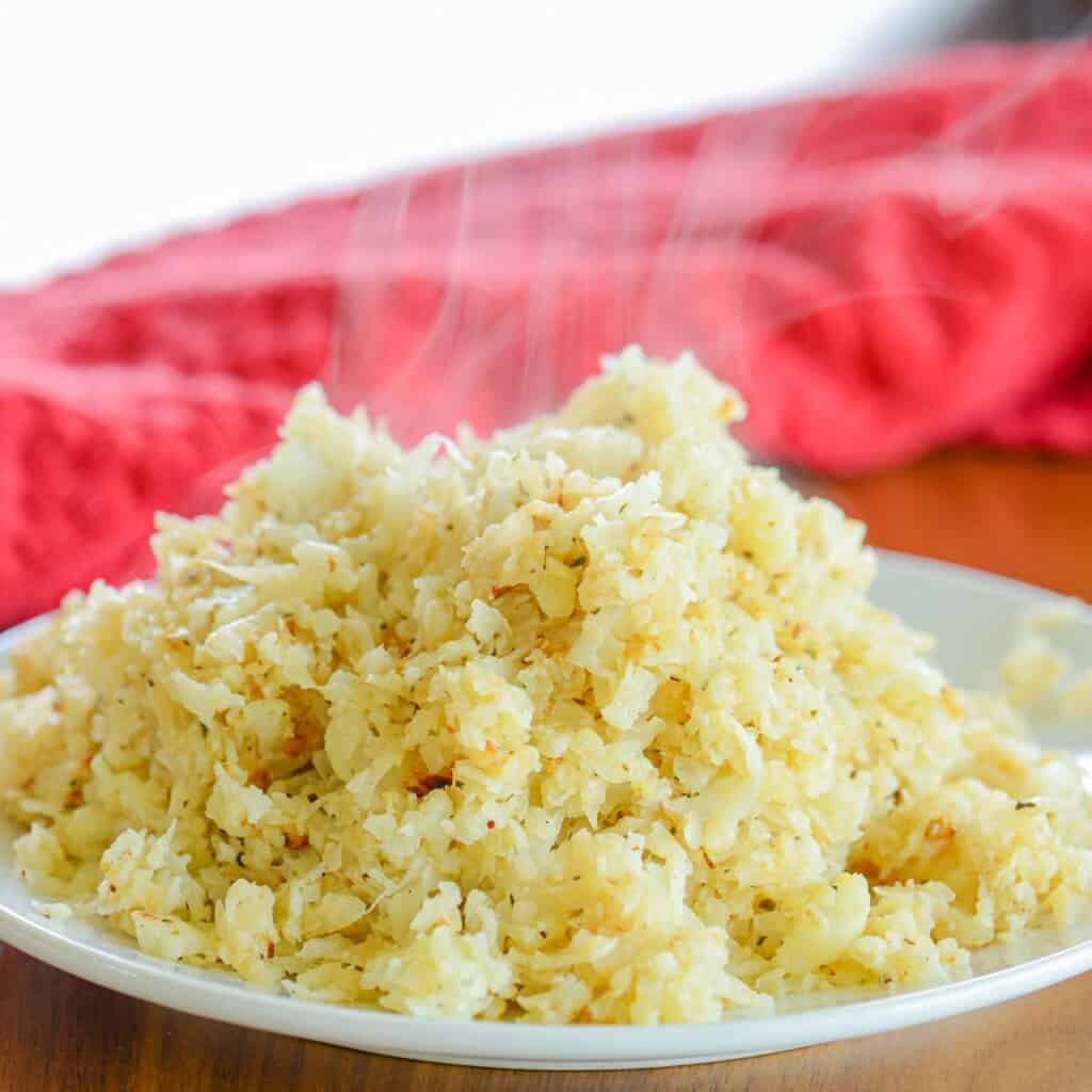 steaming bowl of cauliflower rice seasoned with butter and herbs