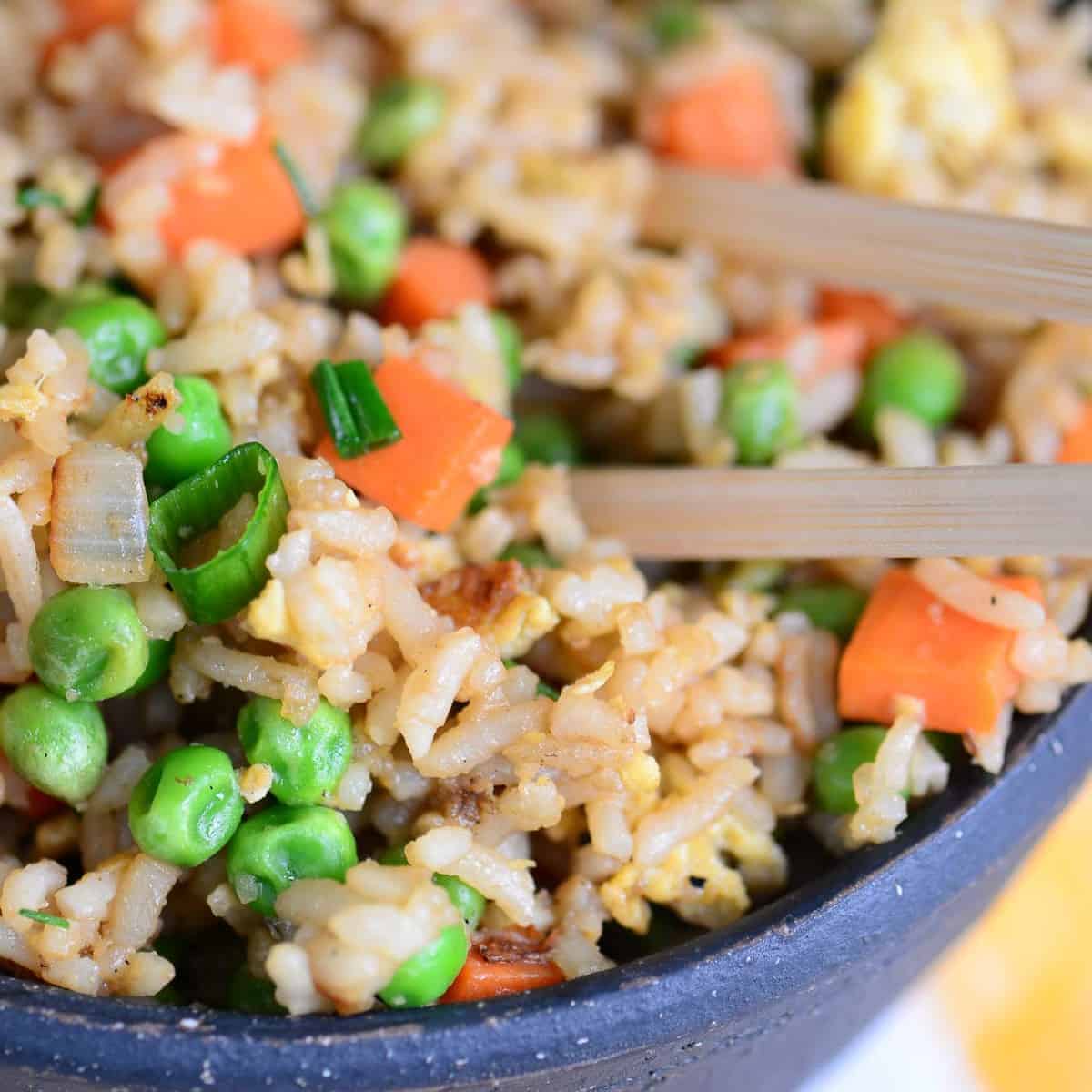 take out style fried rice with chopsticks in a black bowl