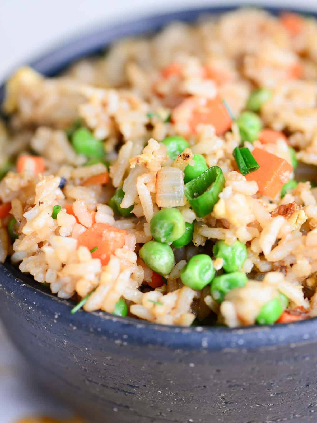 easy take out style fried rice recipe in a black bowl with chopsticks