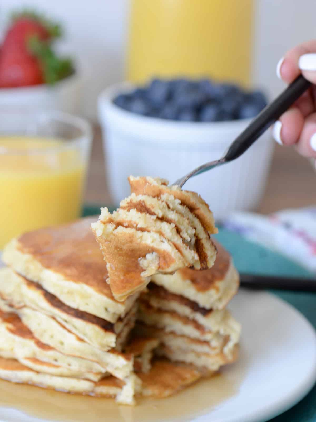 a forkfull of buttermilk pancakes with maple syrup