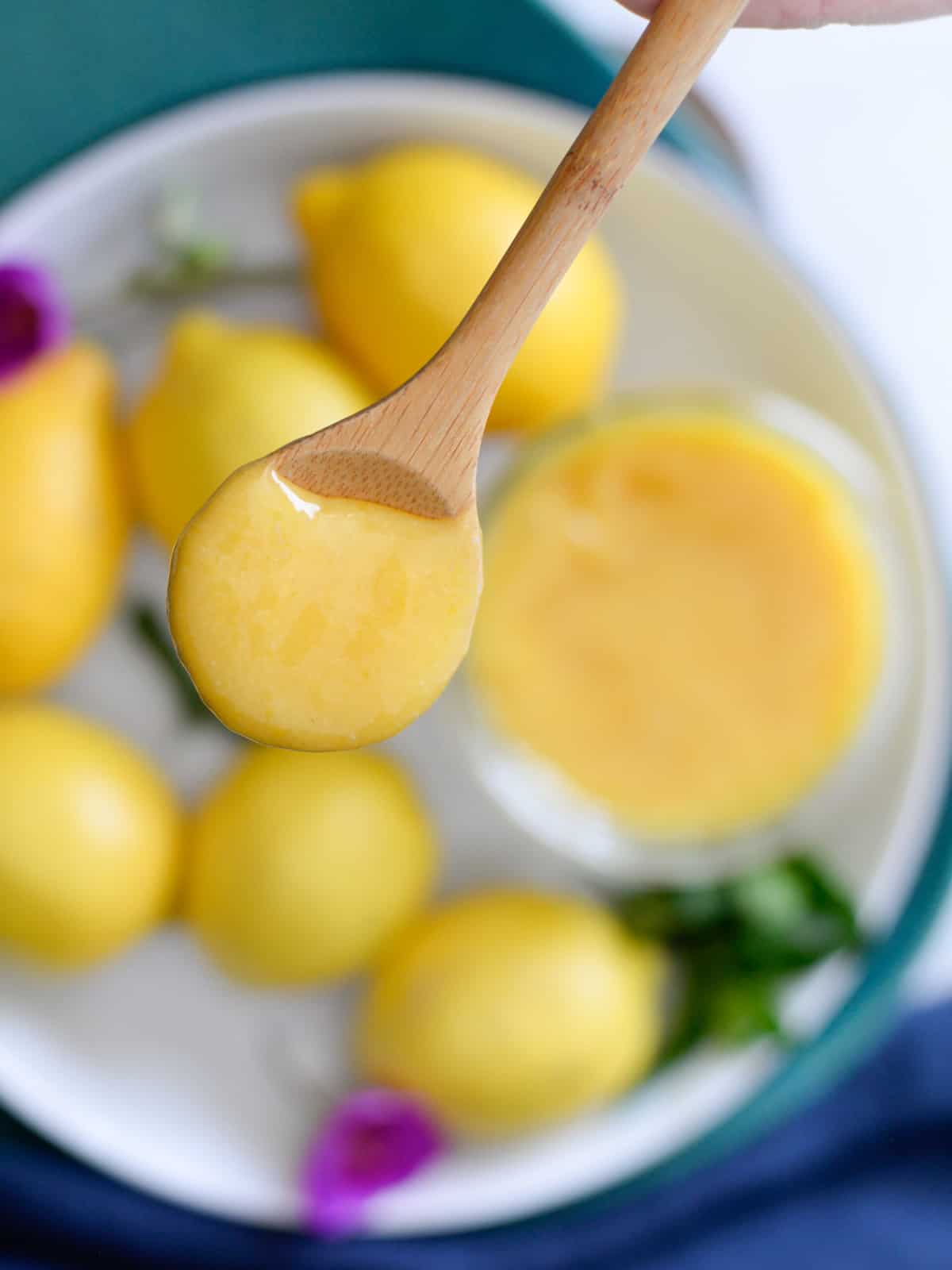 a spoonful of lemon curd on a wooden spoon