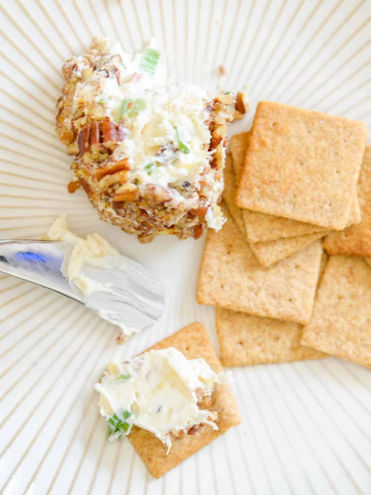 pineapple cheese ball on a whet thing cracker with a pineapple knife