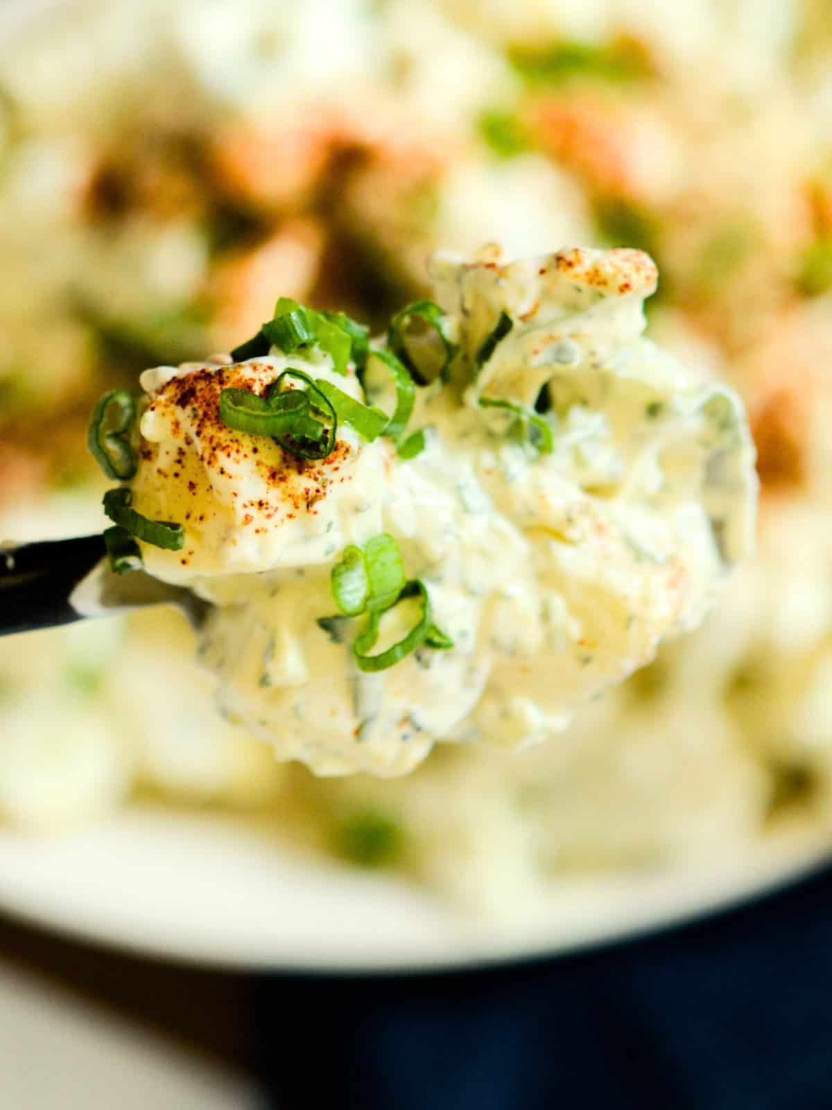a bite of classic potato salad on a fork ready to dig in