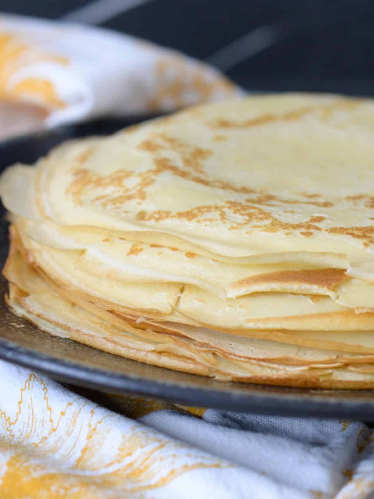 stack of homemade french crepes on a black plate