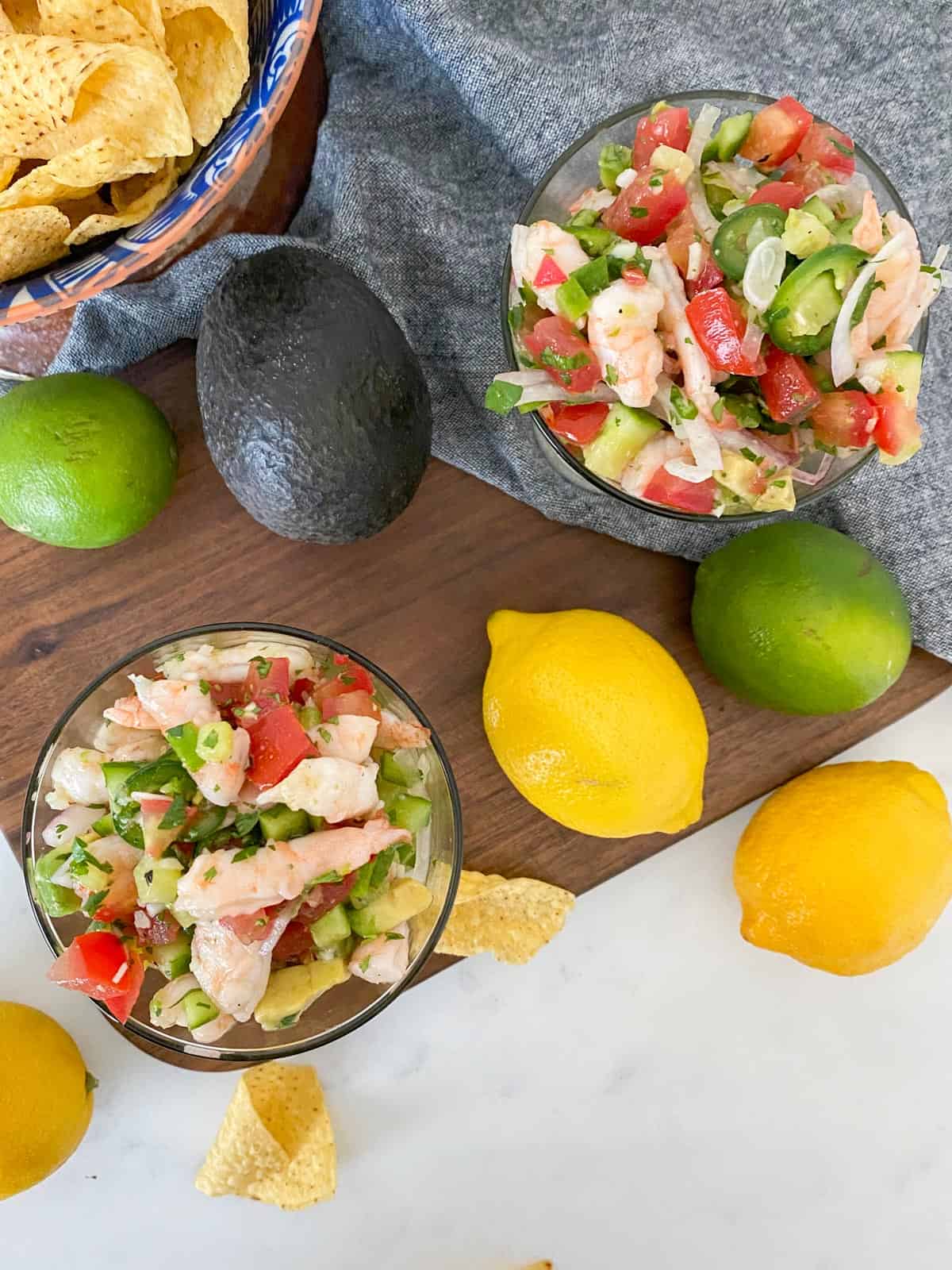 shrimp ceviche pictured with fresh lemons, limes, avocados, and tortilla chips