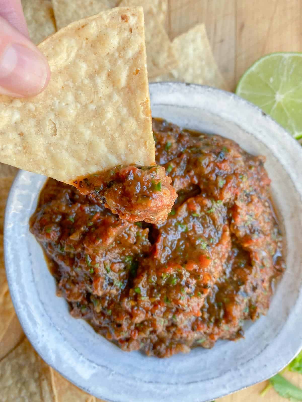 chips and salsa in a white bowl with fresh limes