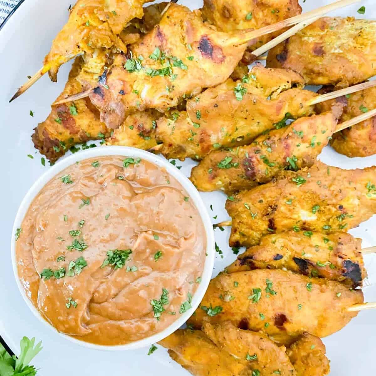 chicken satay appetizer served with a side of peanut sauce