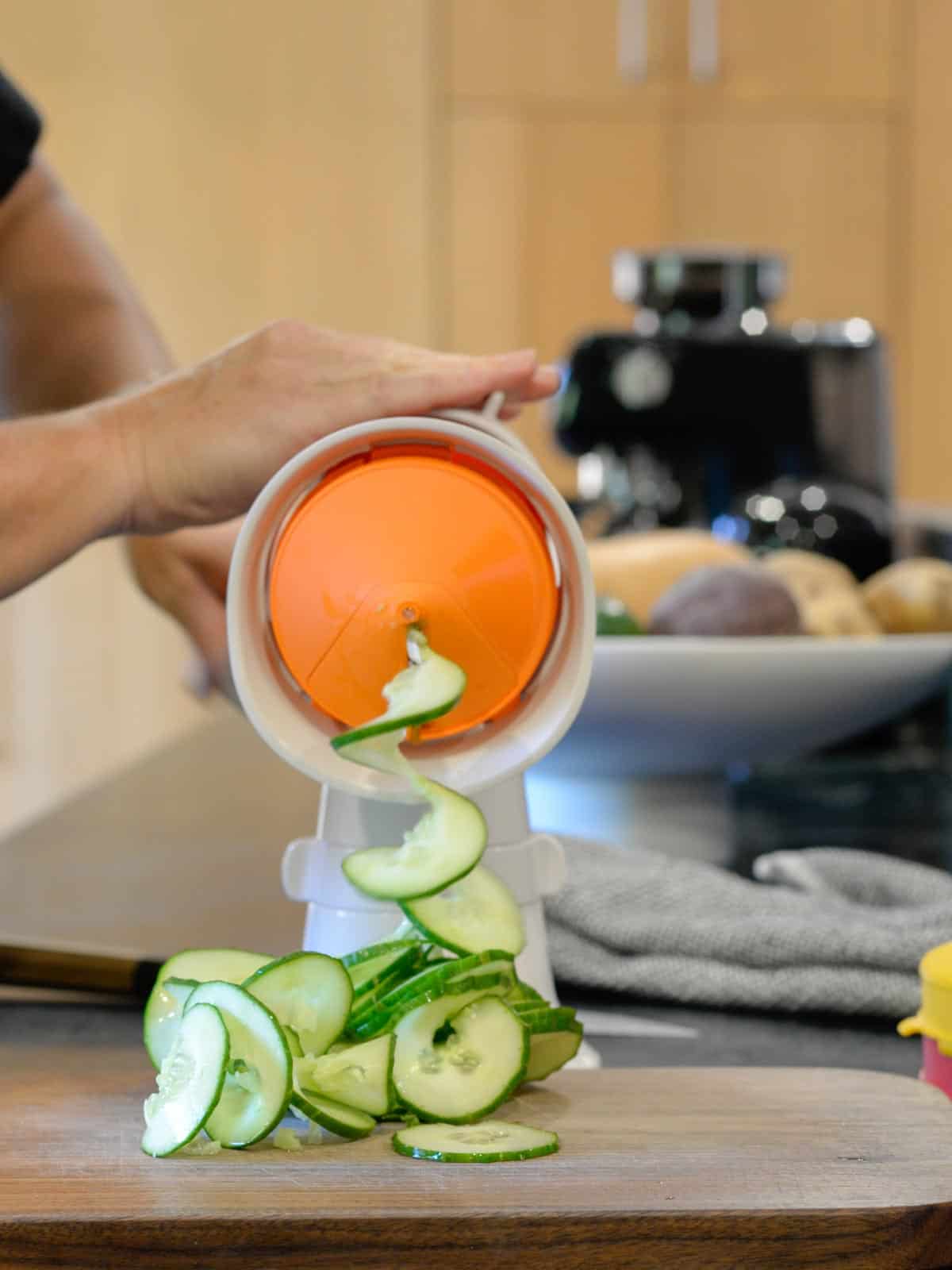 the tupperware spiralizer with the flat blade spiralizing cucumbers