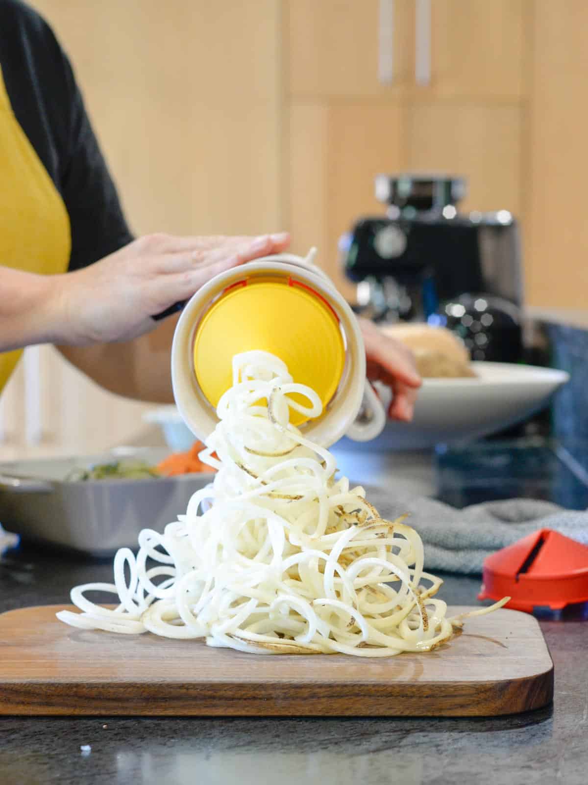 the tupperware spiralizer with the flat blade spiralizing a potato