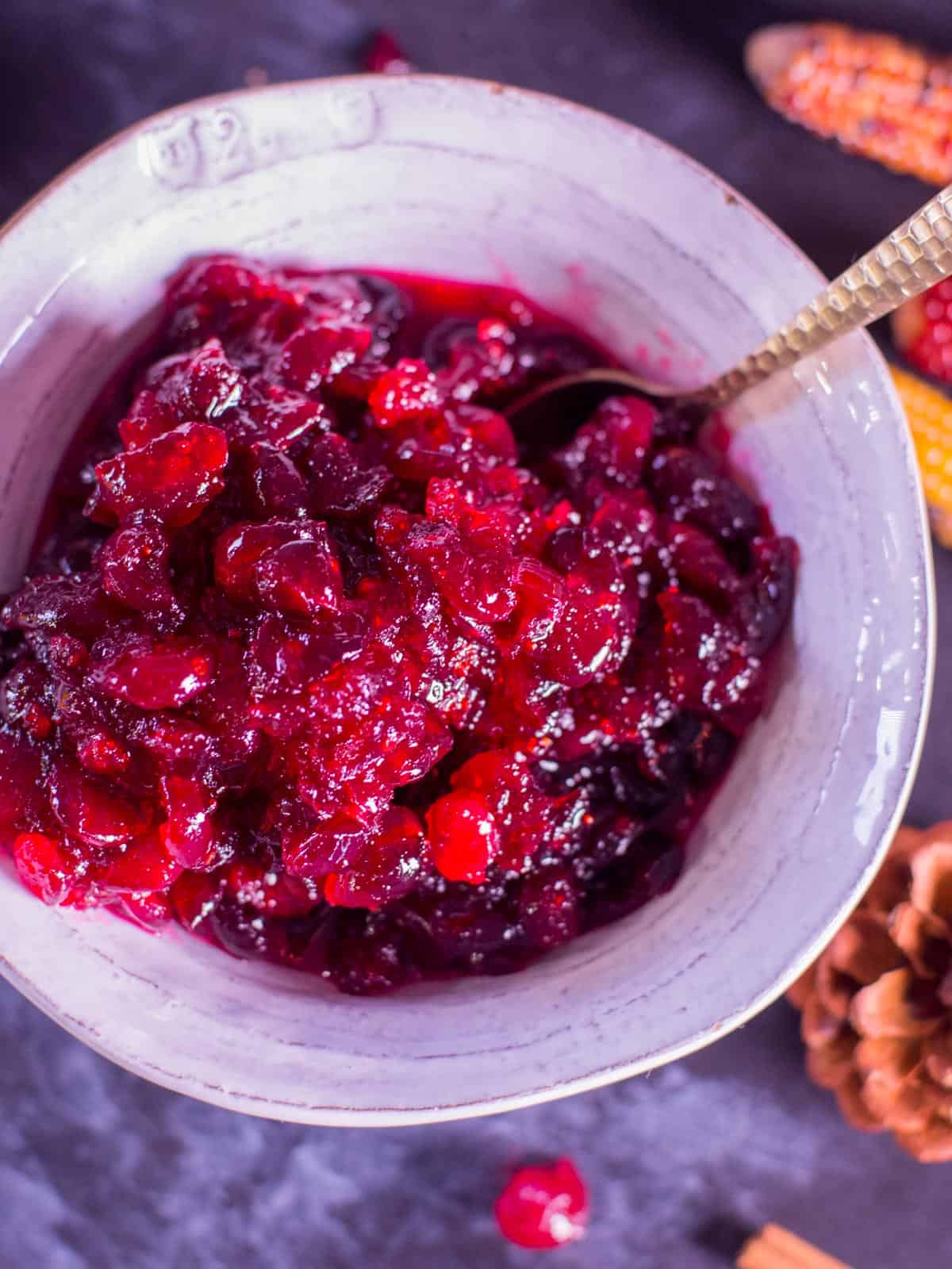 cranberry sauce recipe made with brandy, served in a white bowl with a gold spoon