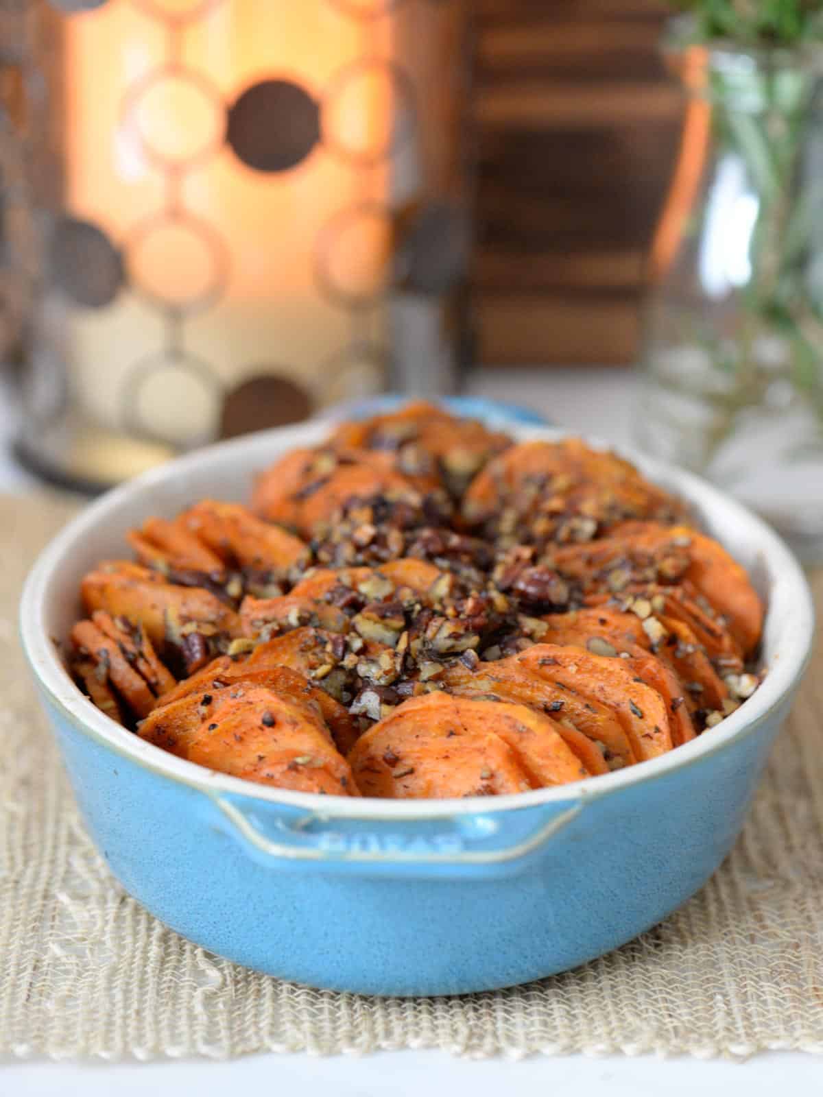 Sliced sweet potatoes, roasted with pumpkin pie spice and rosemary, topped with roasted pecans