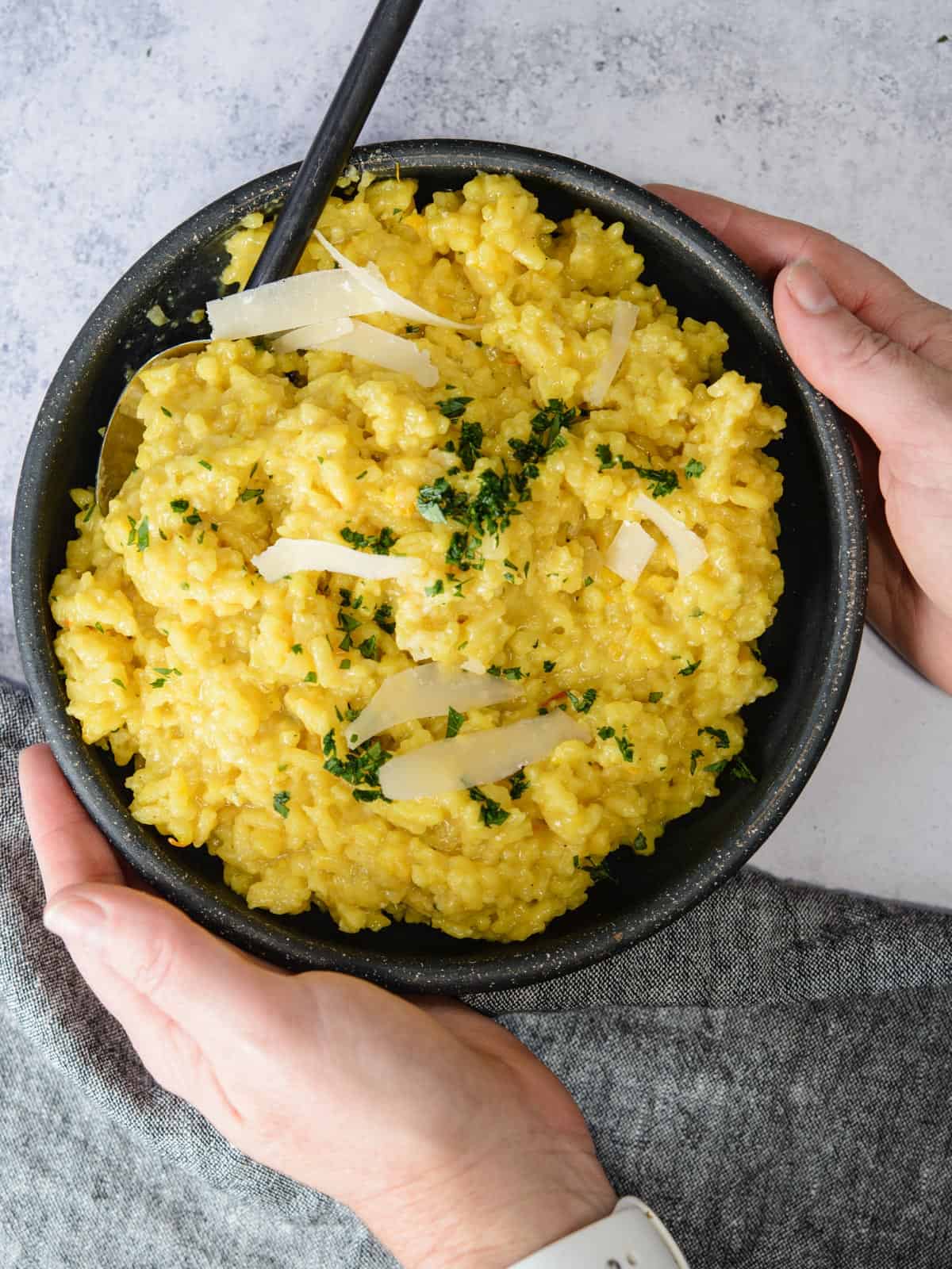 serving risotto garnished with parmesan and parsley