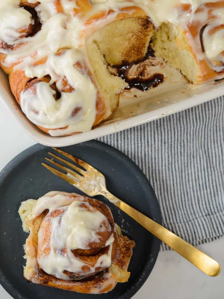 a baking dish of cinnamon rolls and one served on a plate