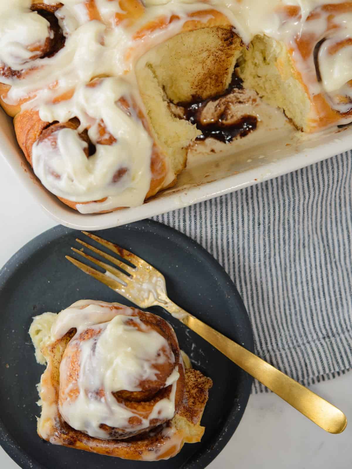 a baking dish of cinnamon rolls and one served on a plate