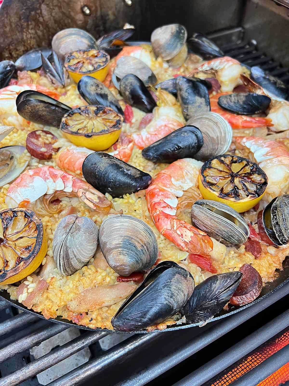 paella cooked on the grill in a cast iron skillet