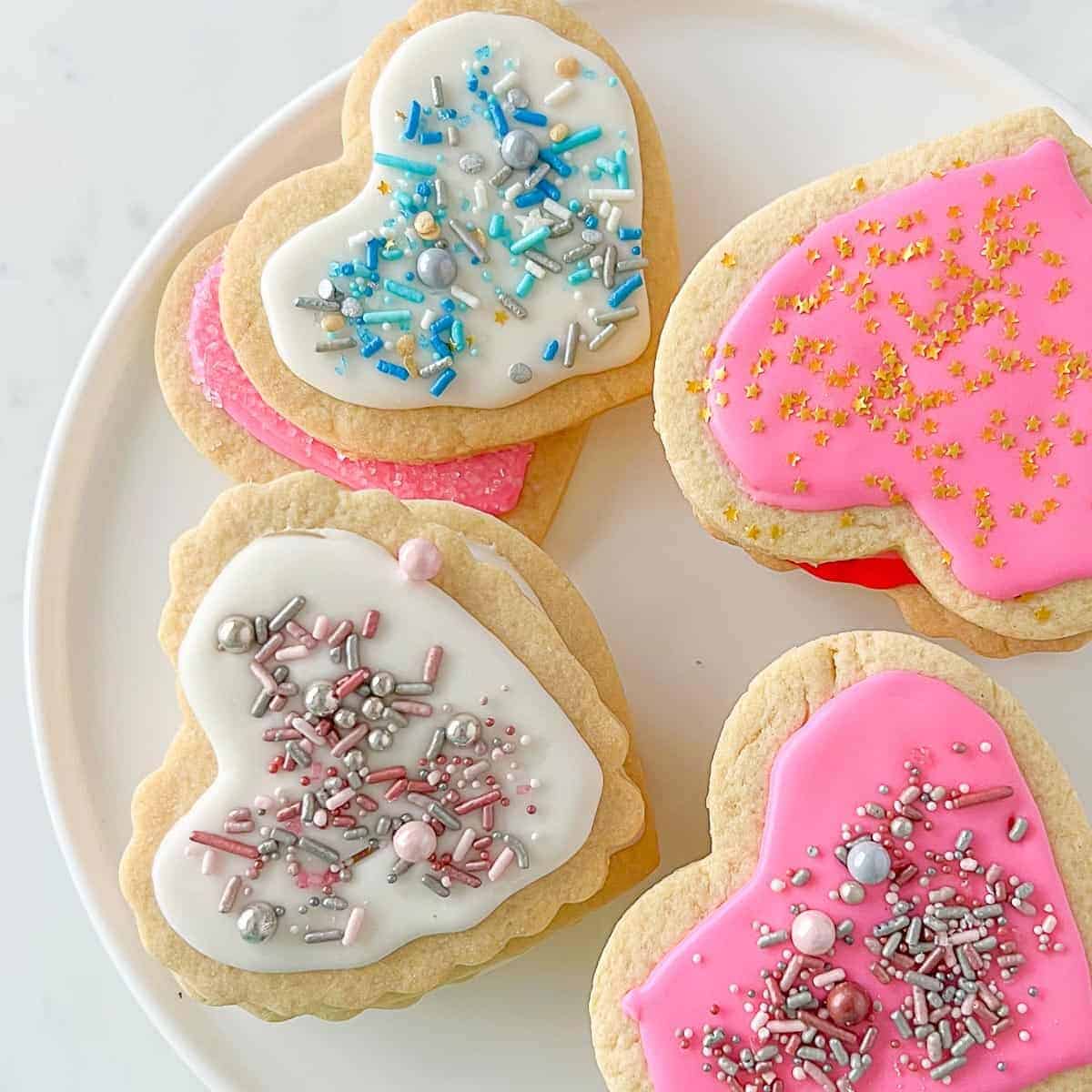 heart-shaped cut out sugar cookies with colored icing and sprinkles