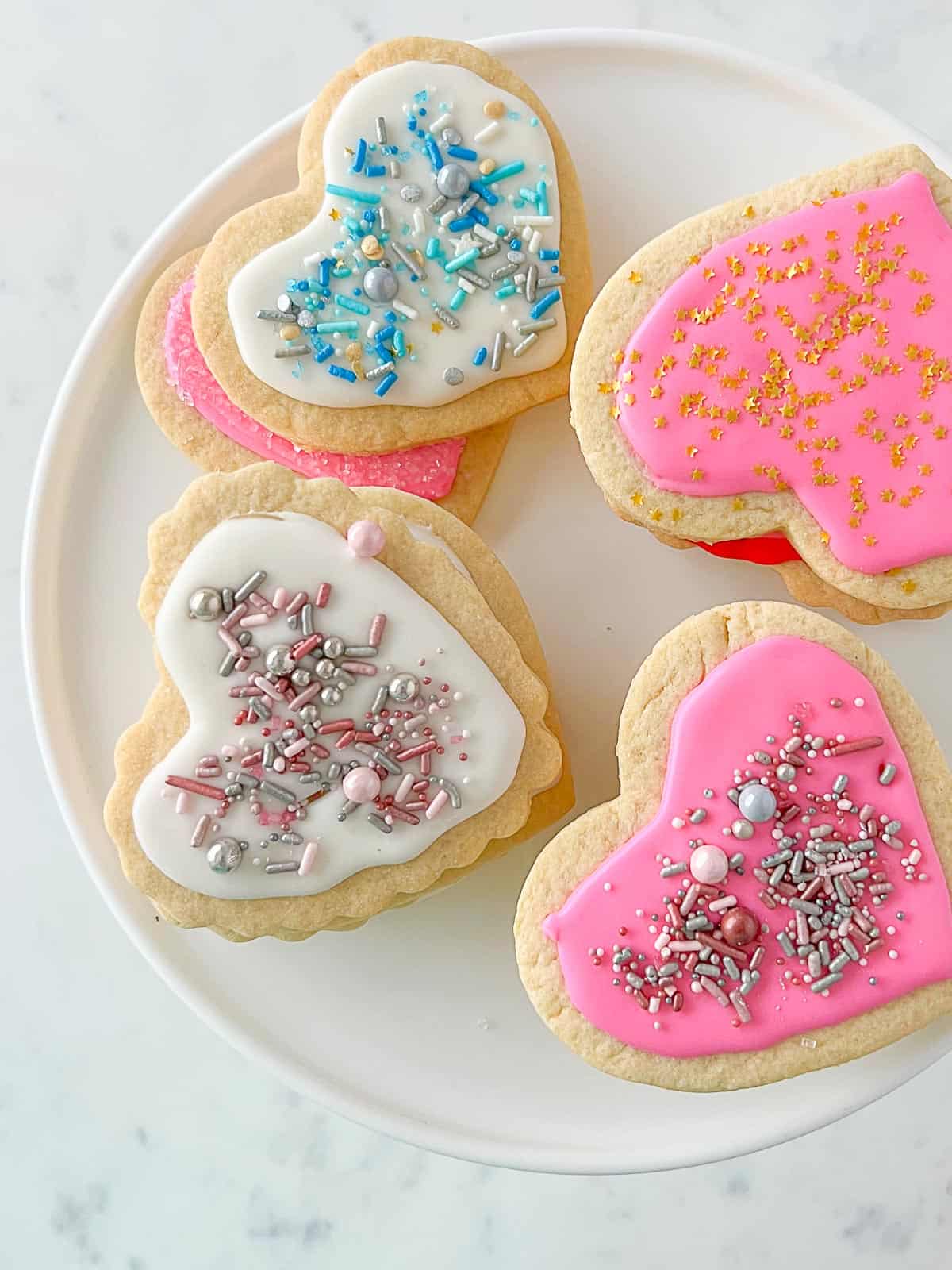 heart-shaped cut out sugar cookies with colored icing and sprinkles