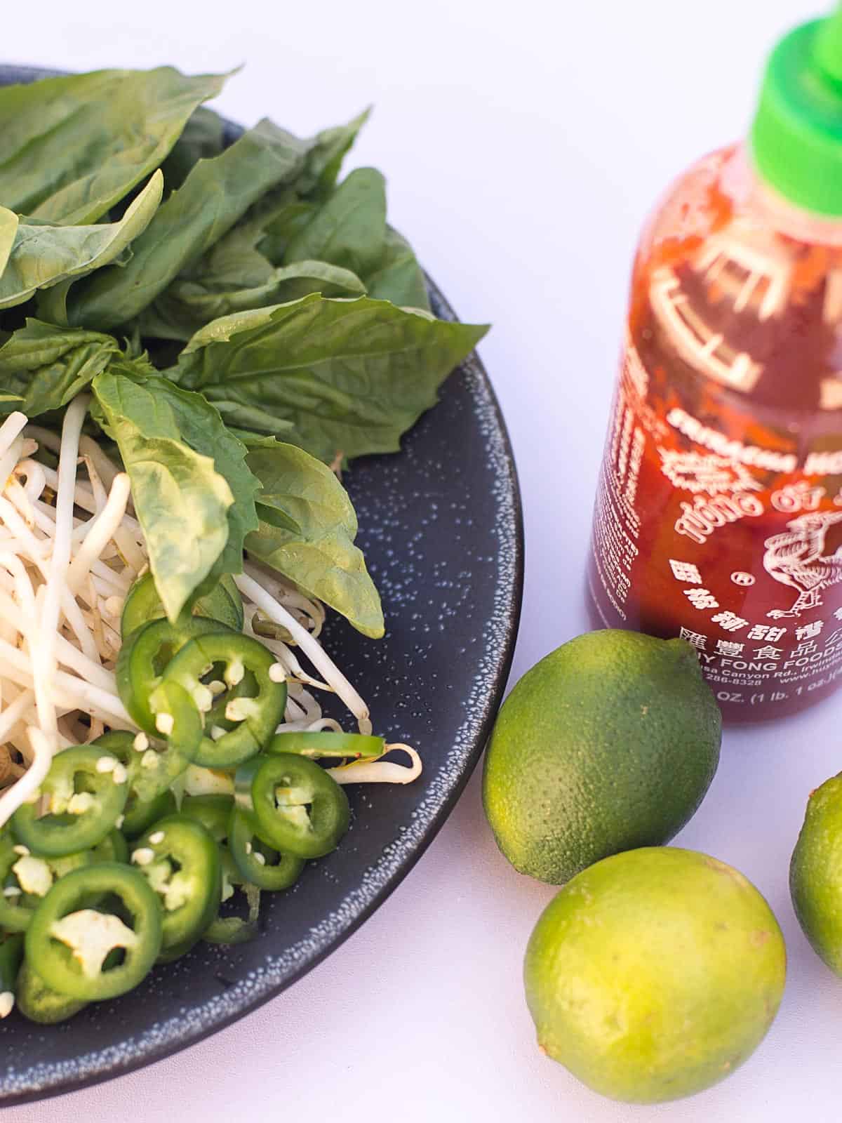 jalapenos, bean sprouts, fresh herbs, limes, and sriracha