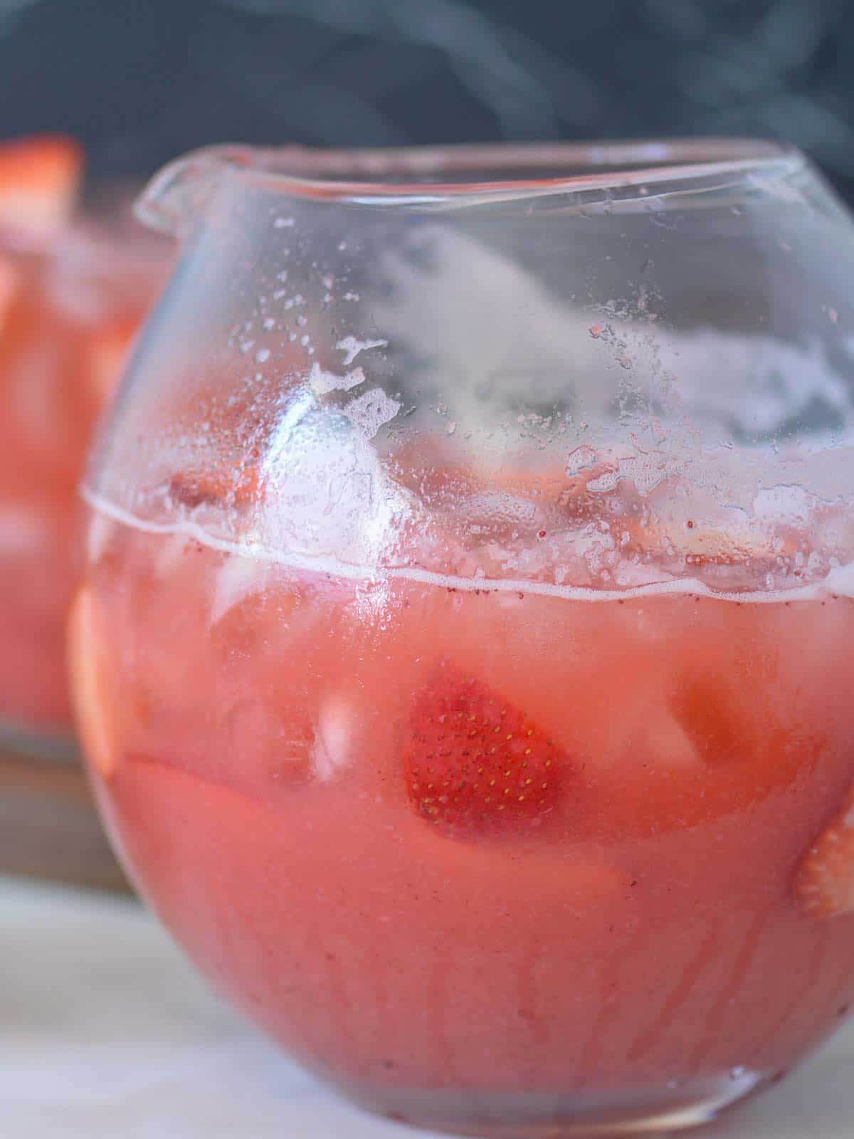 a pitcher of icy cold strawberry agua fresca