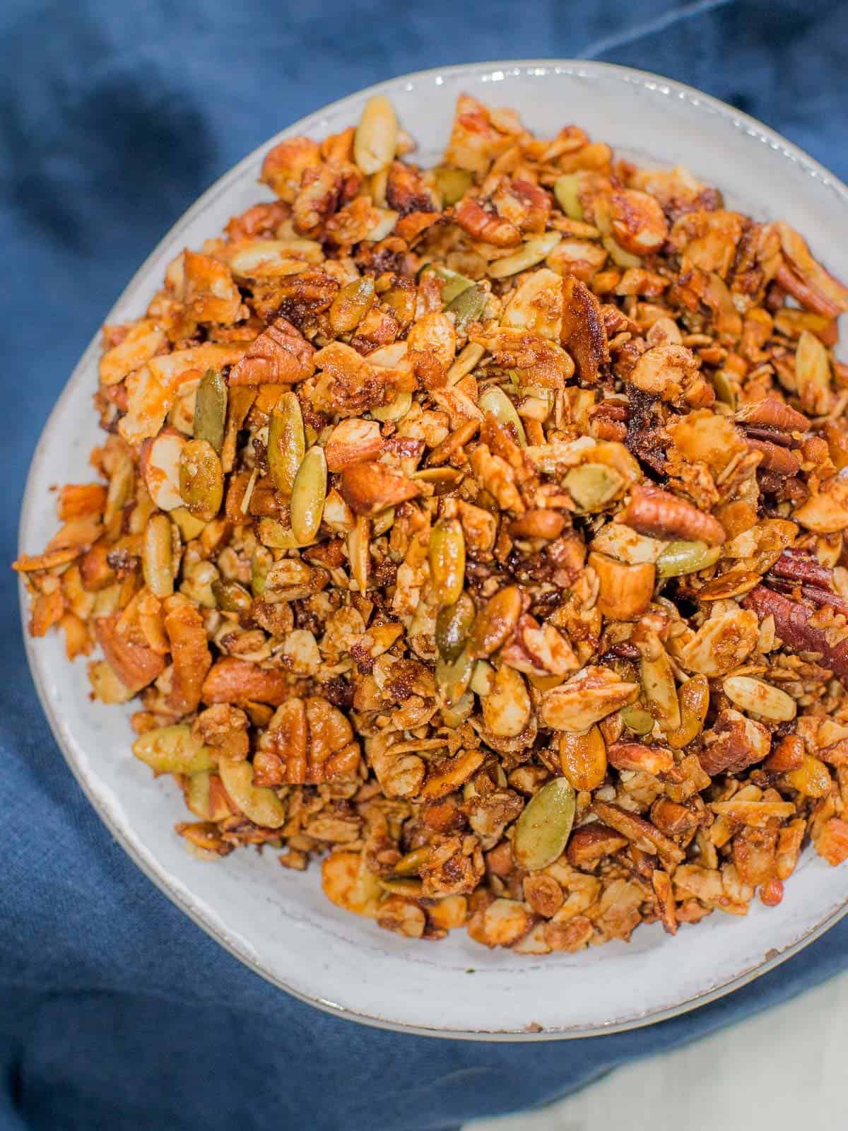 a bowl of pumpkin spice granola with a blue napkin in the background