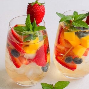 2 glasses of white wine sangria with berries and mangos