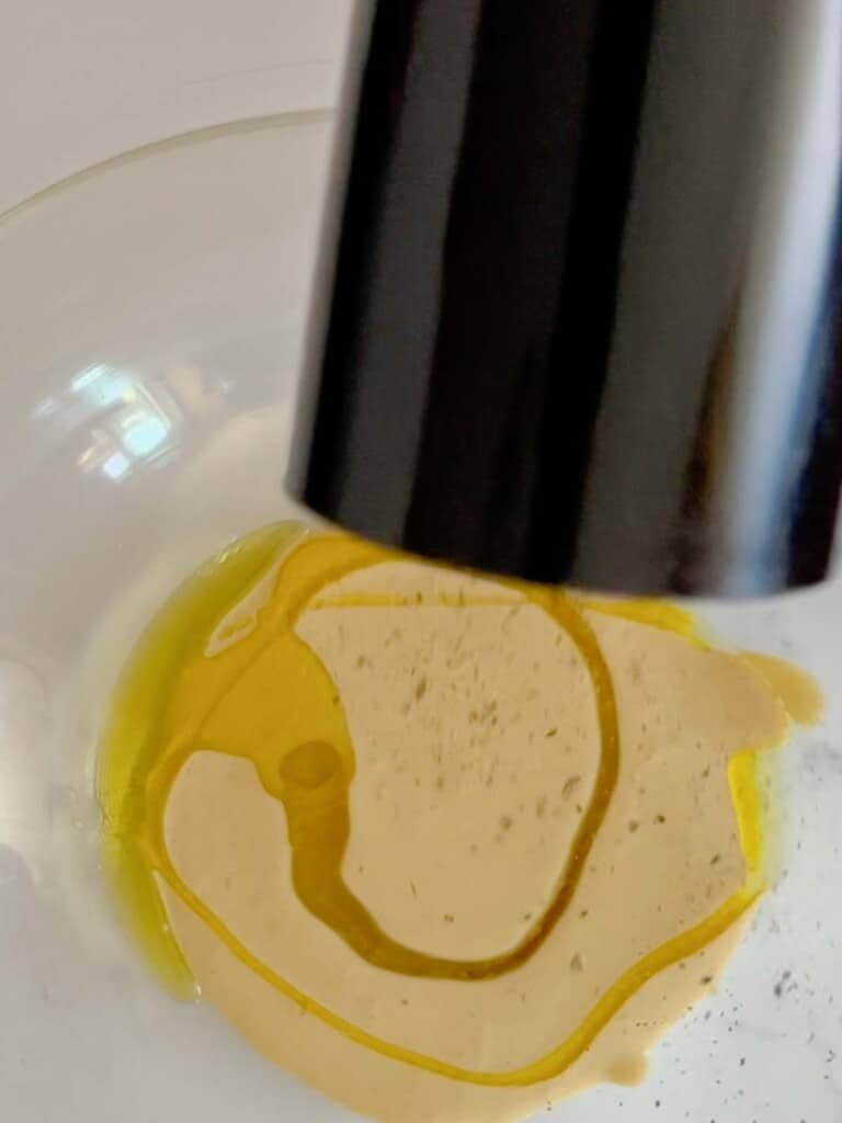 add a llittl it of olive oil and black pepper to the emulsified caesar dressing.