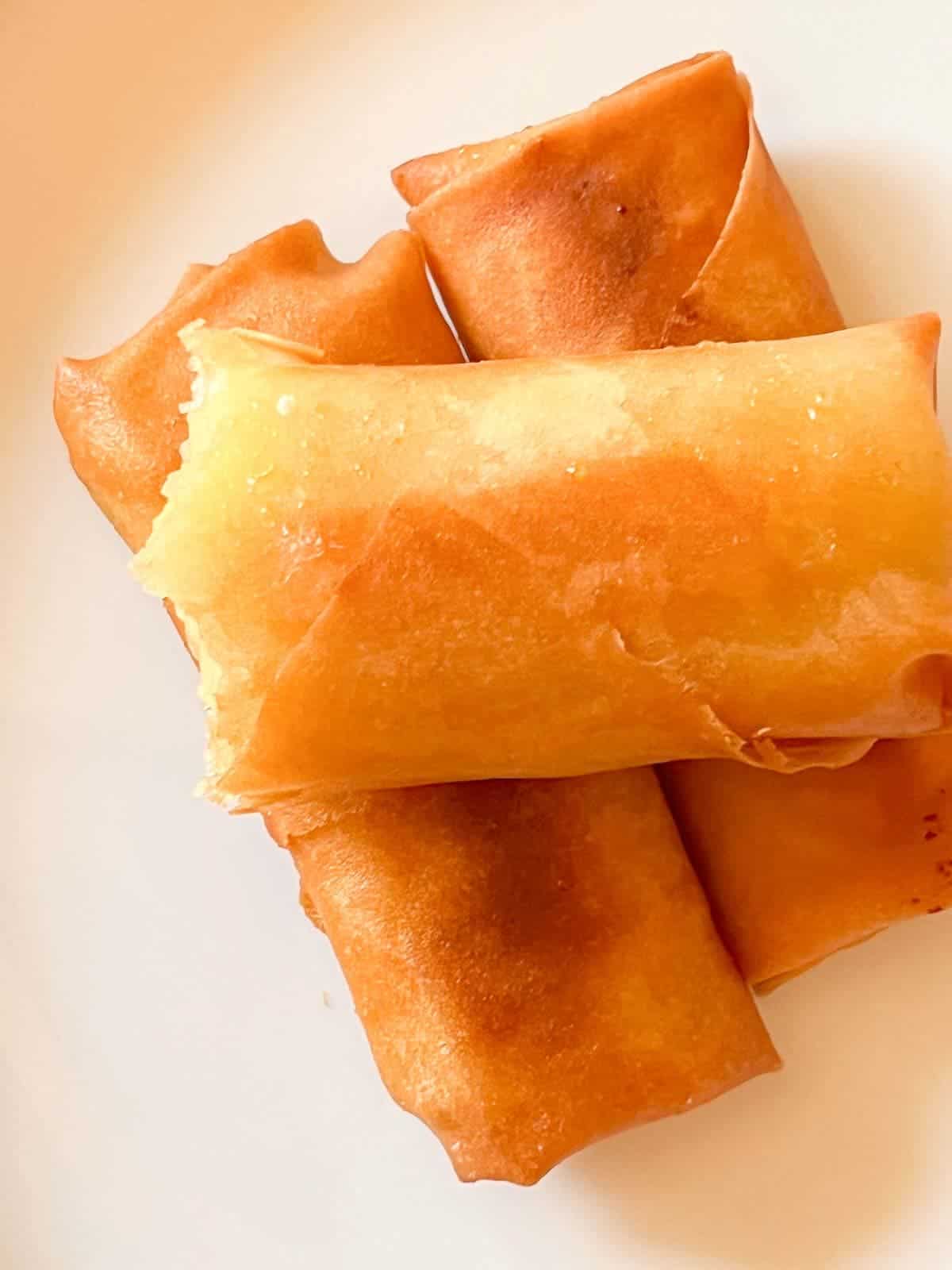 deep fried banana lumpia stacked on a plate