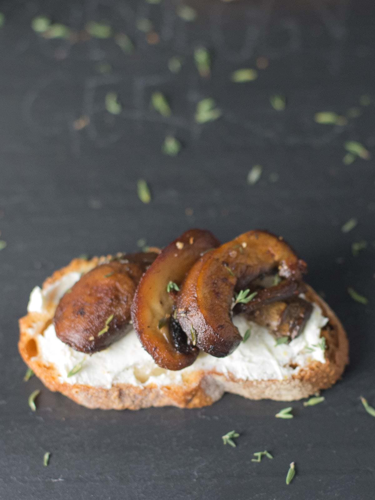 mushroom crostini on a black slate board