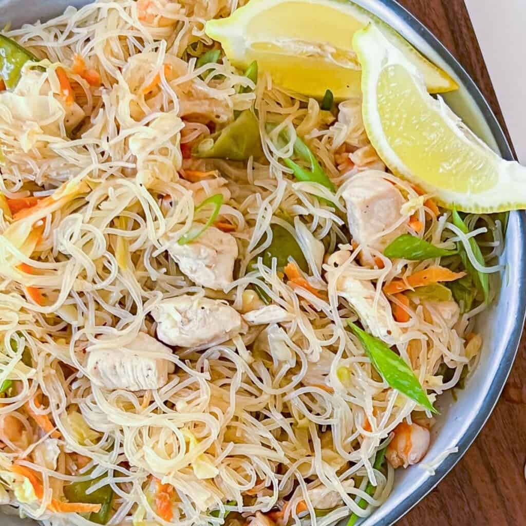 pancit noodles with chicken and shrimp in a white bowl