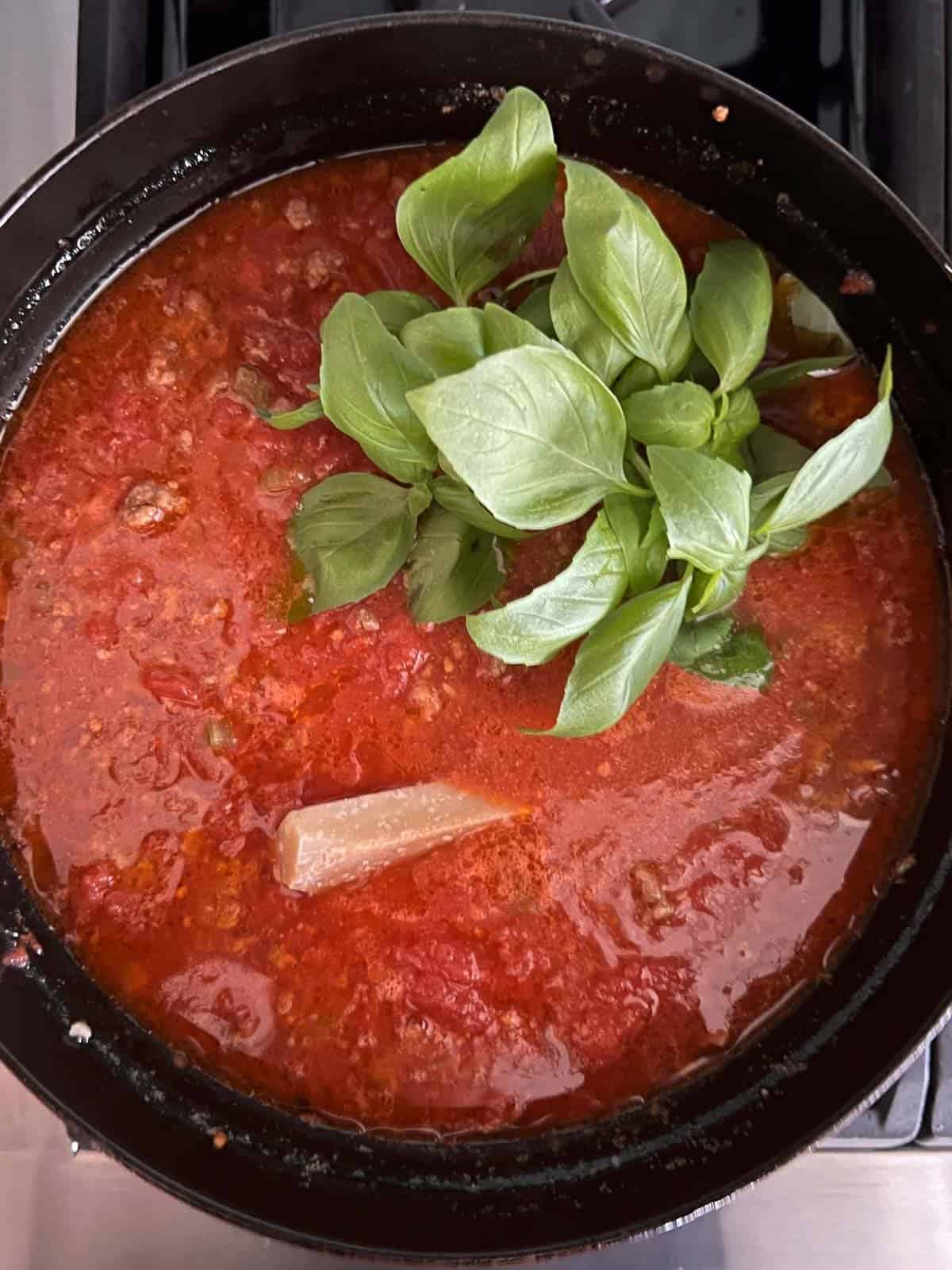 add a handful of fresh basil and the rind from parmesan cheese