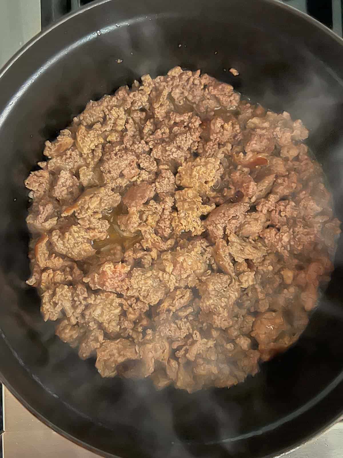 browning ground beef and ground pork in a cast iron dutch oven