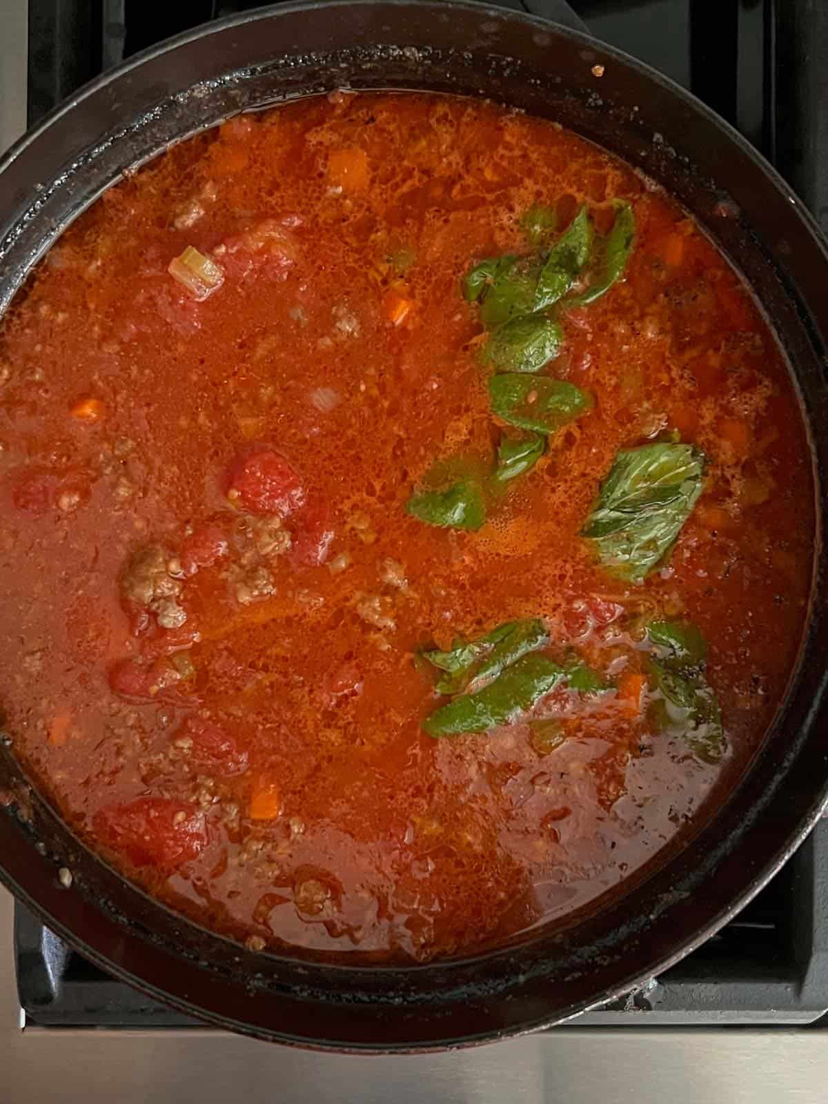 A pot of bolognese sauce in a dutch oven after it's been simmering for 4 hours