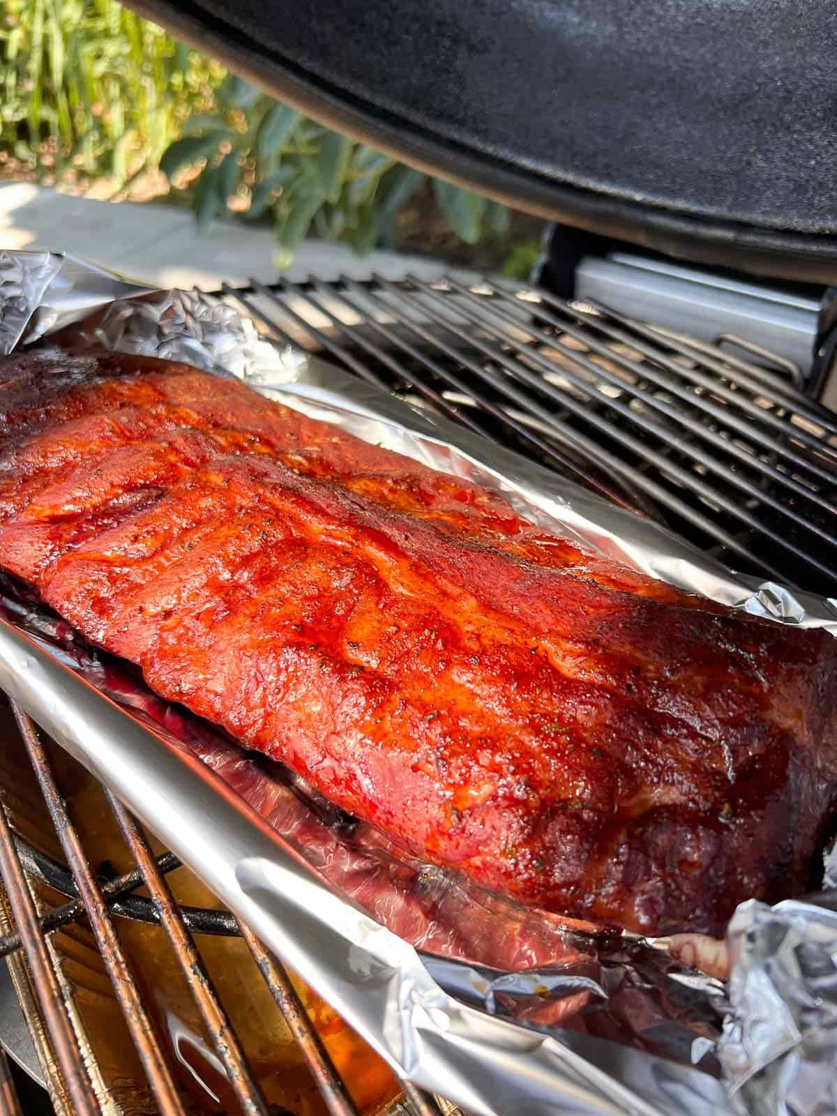 ribs on the smoker fitted with a foil boat to protect the bottom from overcooking