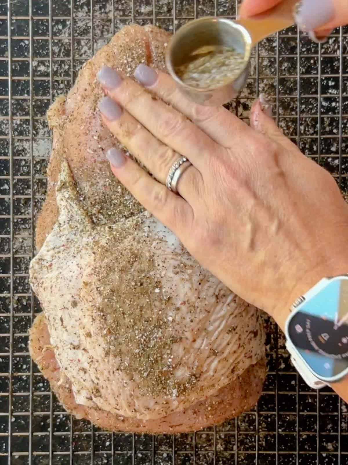 a turkey breast being seasoned with dry rub seasoned with