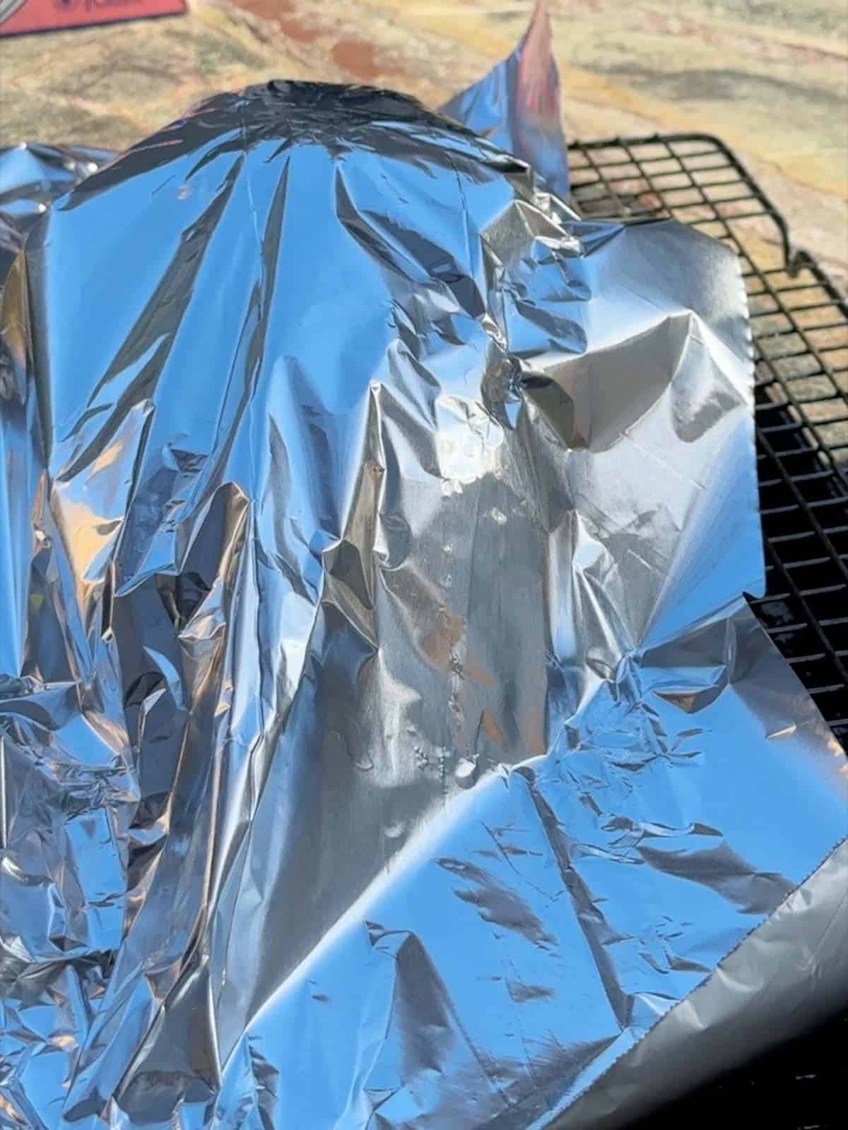 a turkey breast being tented with foil