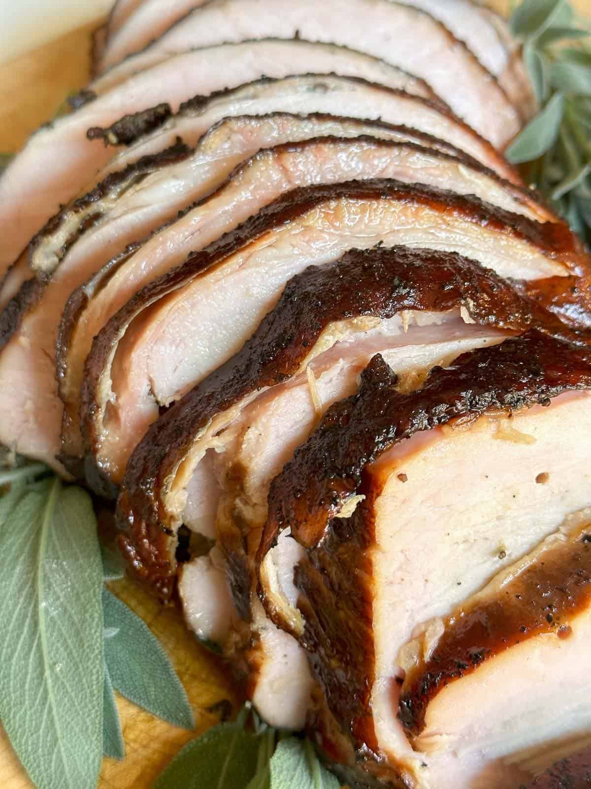 smoked turkey breast sliced and pictured on a cutting board 