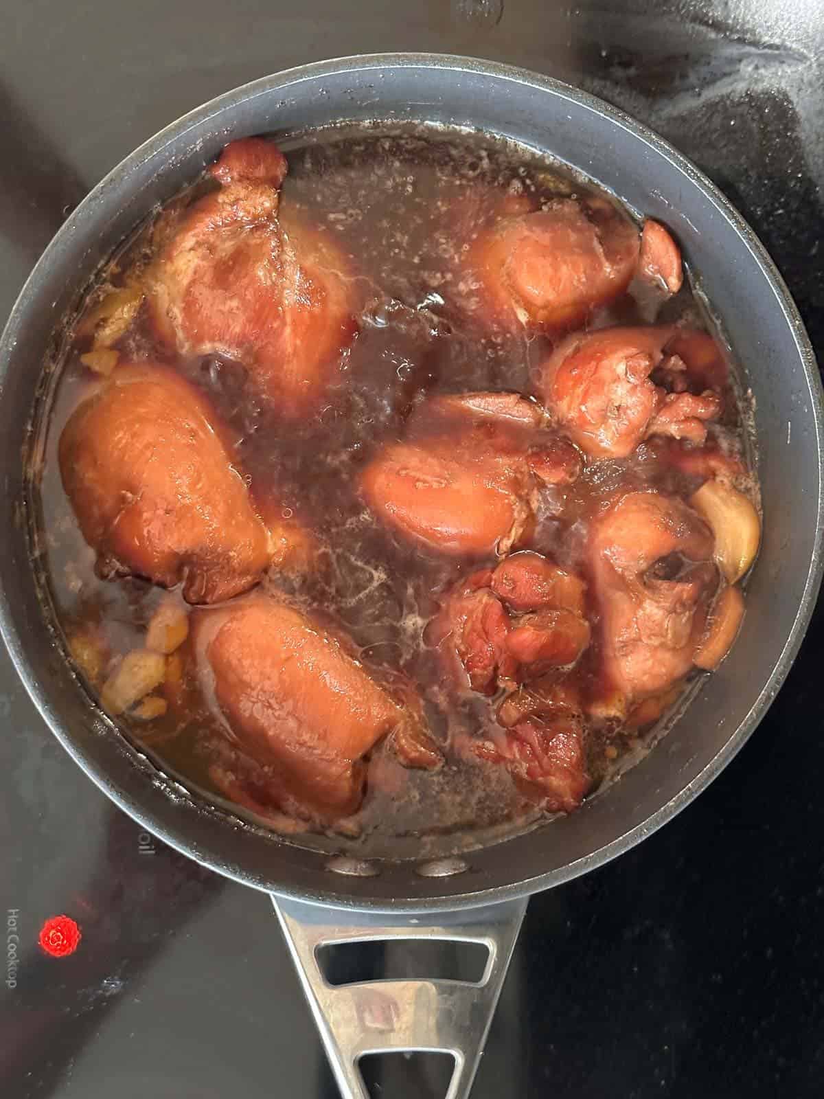 shoyu chicken simmering in shoyu broth