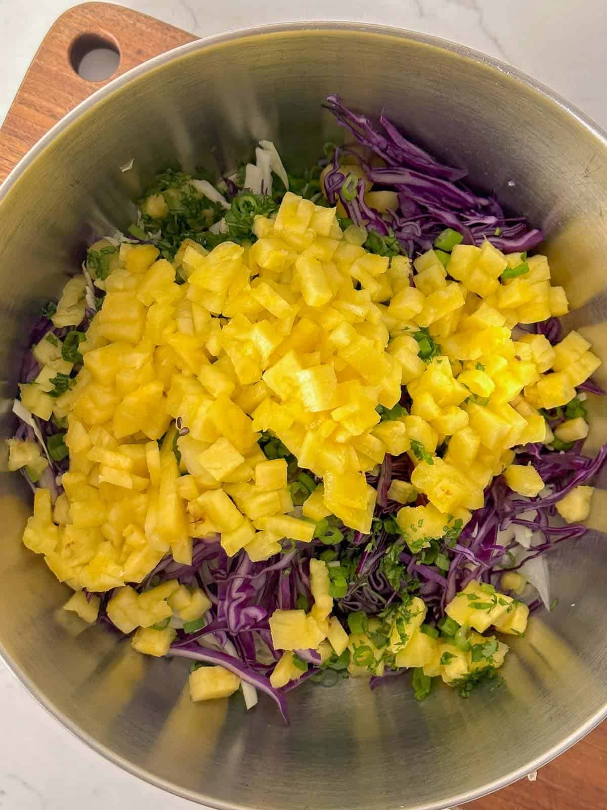 ingredients for pineapple coleslaw in a bowl before stiring