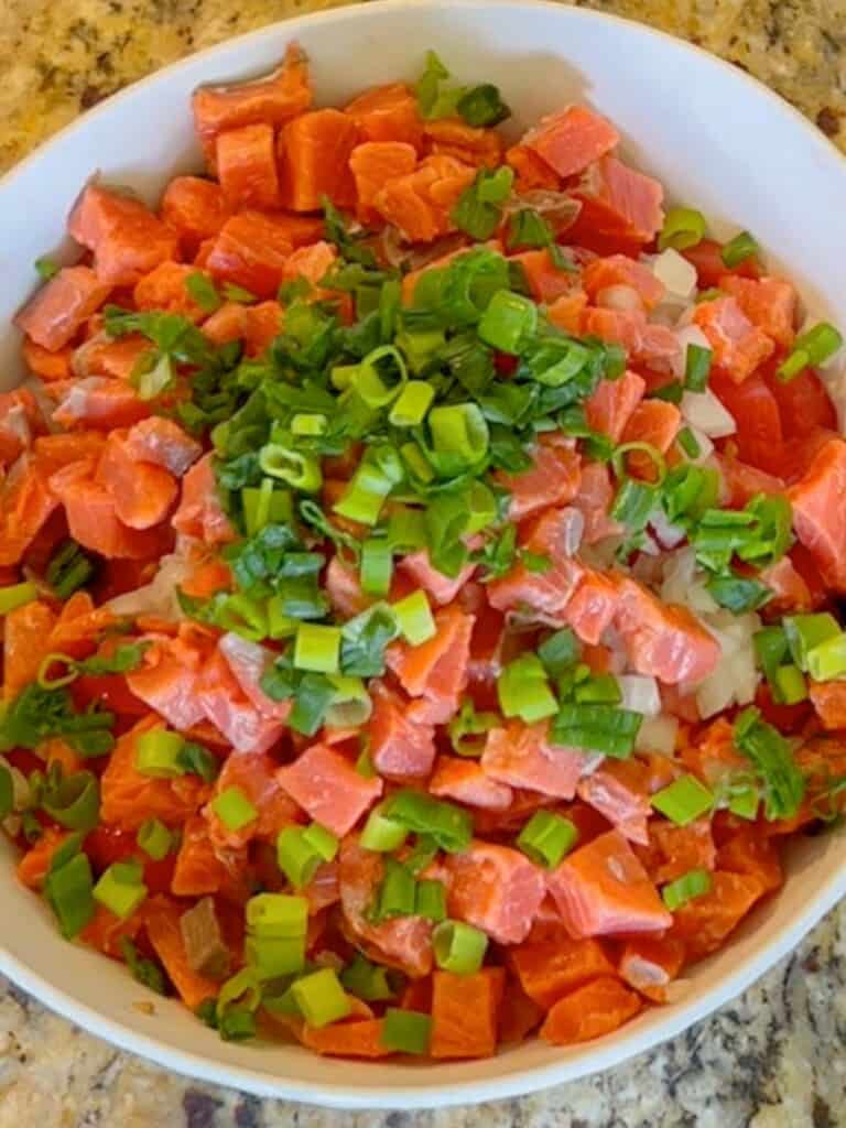 Making lomi lomi salmon, top with green onions